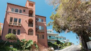 A multi-story building with a pink facade, balconies, and a staircase. - RelaxBeachPad Beachside Studio!Parking&Laundry (San Pedro)