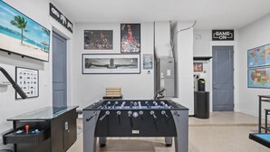 Ein Raum mit mehreren Kicker-Tischen, jeweils mit einem roten, blauen, weißen, schwarzen und gelben sowie grünen Ball.