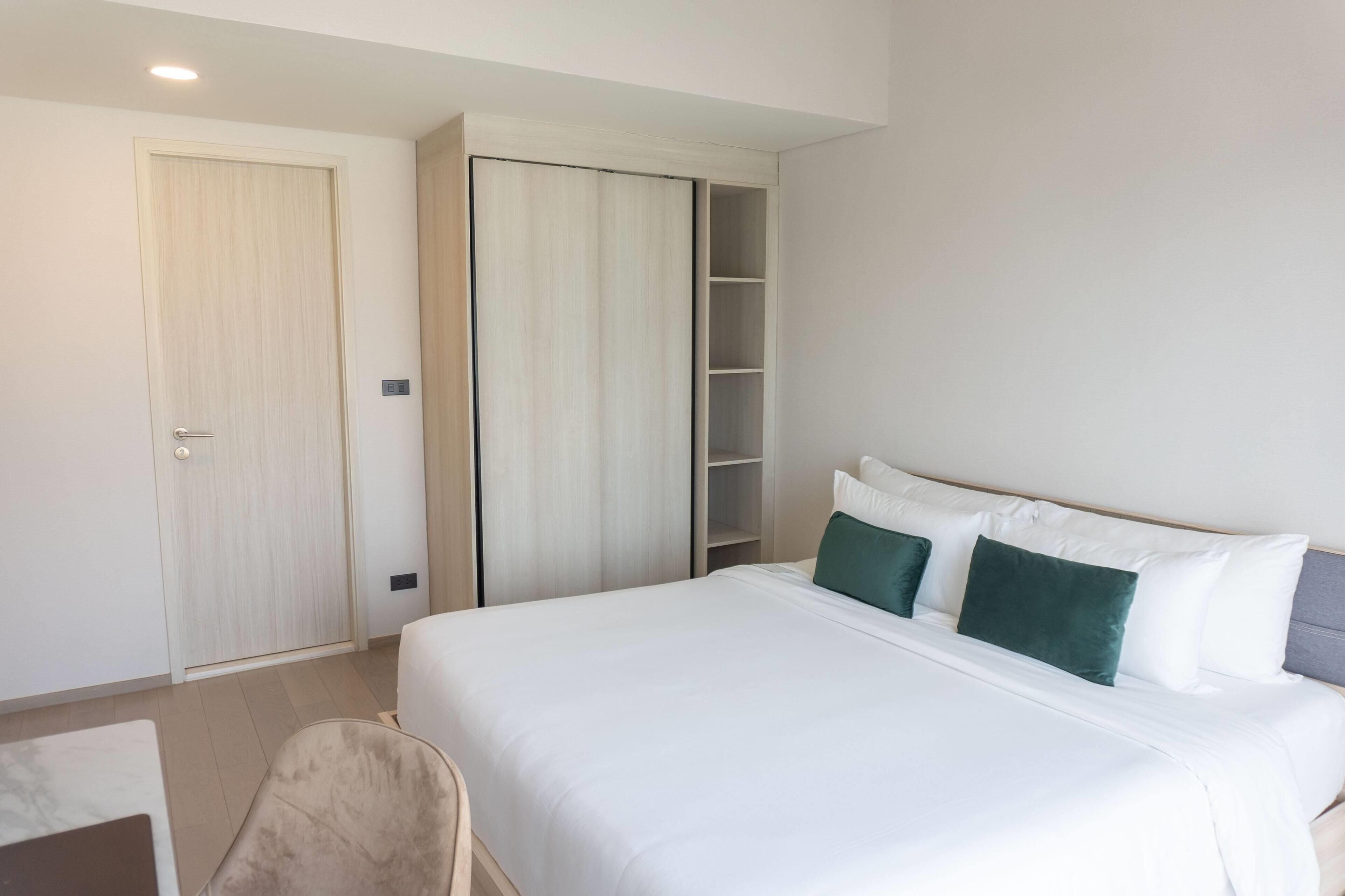 A hotel room with a bed, a wardrobe, and a seating area.