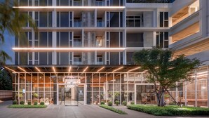 A multi-story hotel with a modern design, featuring a glass facade, a central entrance, and a landscaped courtyard. - Wyndham Garden Bangkok Sukhumvit 42 (Bangkok)