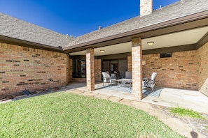 A brick patio with outdoor furniture and a covered area.