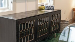 A dark wooden cabinet with arched glass doors, a small vase, and a tissue box on top. - Urban Oasis Spacious King Bed Free Parking (Nashville)