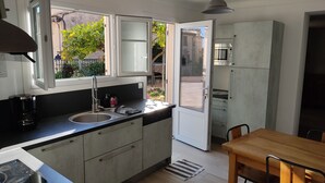 Eine moderne Küche mit Spüle, Kaffeemaschine und einer offenen Tür zu einem Garten.