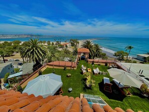 Une terrasse sur le toit offrant une vue sur la plage, les palmiers et un kiosque.
