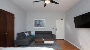 A modern living room with a grey sofa, a wooden coffee table, and a ceiling fan. - Mid Century Modern Beachside. Laundry. Parking (San Pedro)