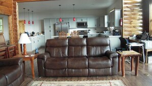 A cozy living room with a brown leather sofa, wooden coffee table, and a patterned rug. - Highland Koselig Lodge (Sevierville)
