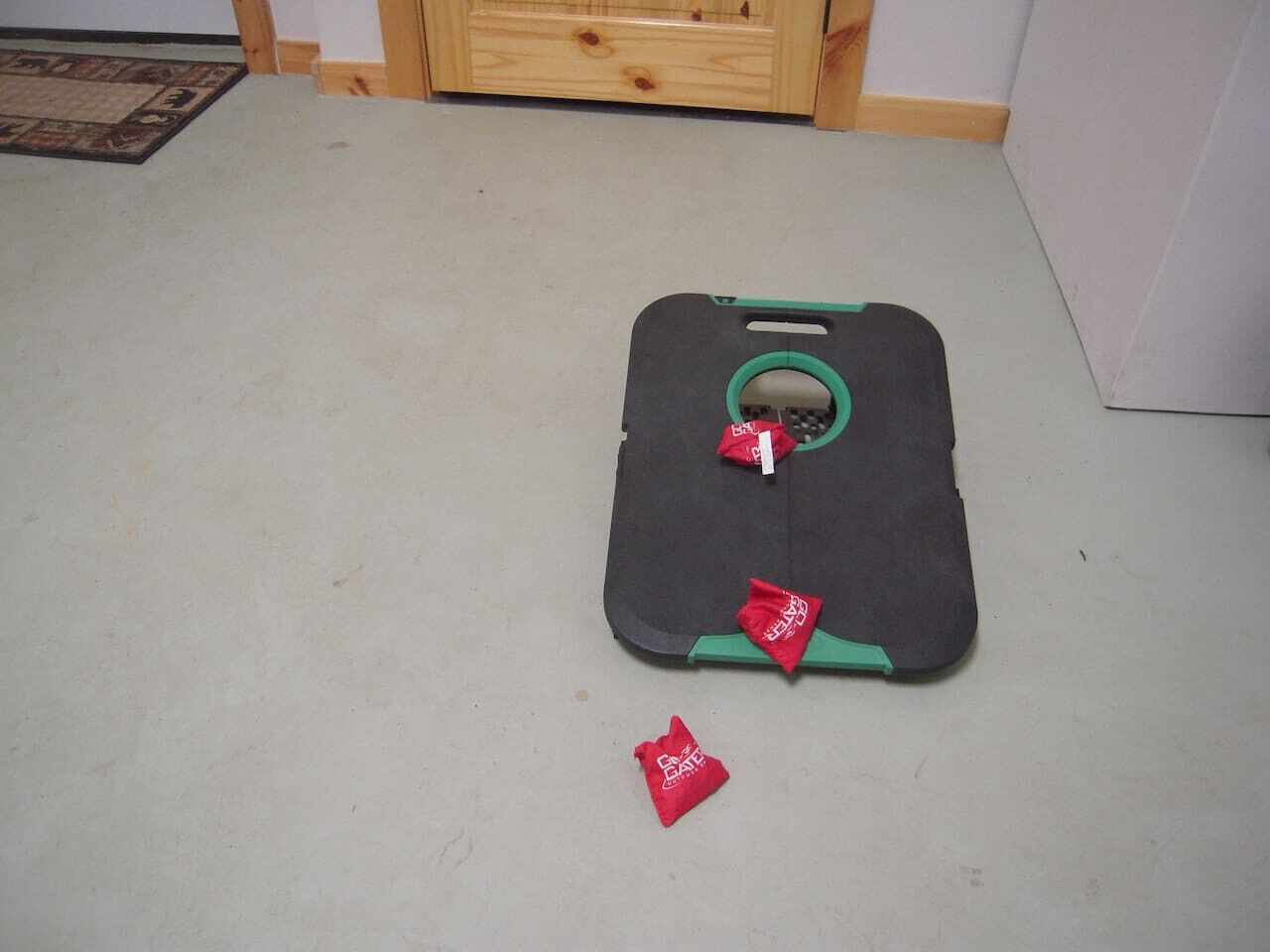 A carpeted floor with a piece of exercise equipment, a mat, and a small red object.