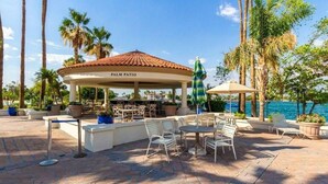 A palm patio with outdoor seating and a view of the ocean. - Val Vista Oasis- Gorgeous Gilbert Home with Pool (Gilbert)