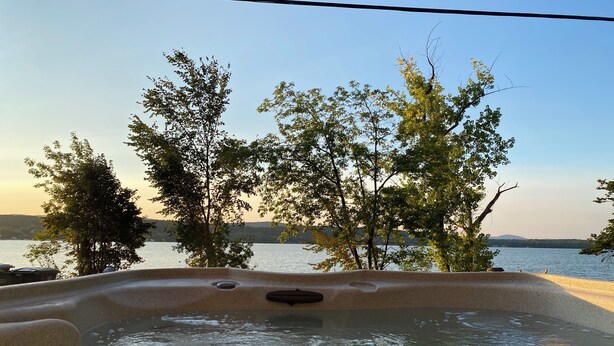 A hot tub with a view of a lake and trees. - Sunrise Lake House, Comfort-Hot Tub-Beach! (Saint Albans)