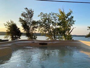A hot tub with a view of a lake and trees. - Sunrise Lake House, Comfort-Hot Tub-Beach! (Saint Albans)