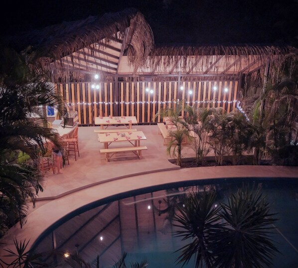Relax by the pool in a serene outdoor lounge area surrounded by lush tropical plants and comfortable seating.
