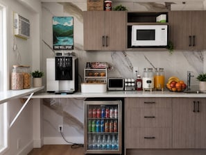 A modern kitchen with a coffee machine, microwave, toaster, and a beverage fridge. - Paradise Motel (Sicamous)