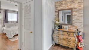 A bedroom with a bed, a dresser, a mirror, and a chandelier. - Nash Riverfront Condo, Sleeps 6, Walk to Broadway (Nashville)
