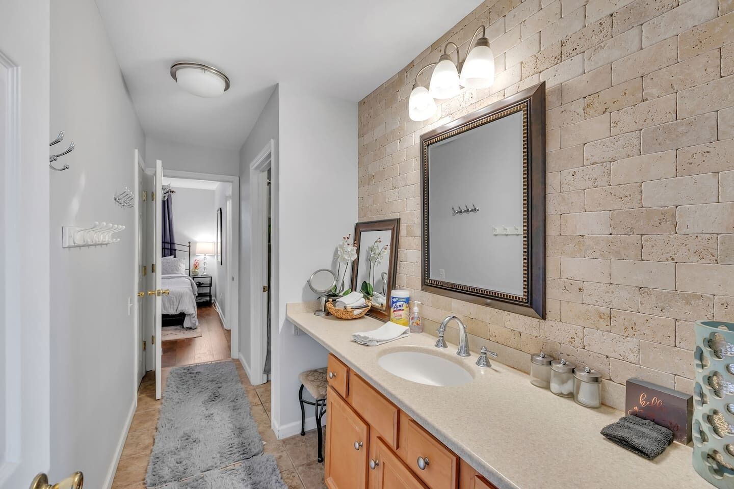 Une salle de bain avec un grand miroir, un lavabo et un meuble-lavabo.