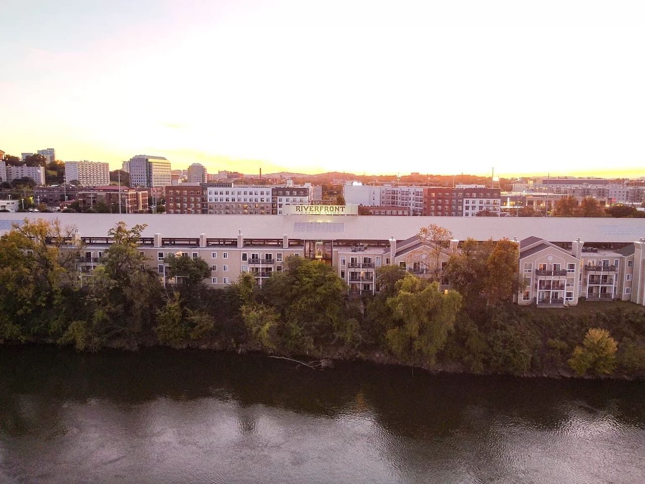 Ein mehrstöckiges Gebäude mit einem Schild mit der Aufschrift 'RIVERFRONT' in der Nähe eines Gewässers.