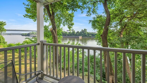 A covered outdoor area with a view of a river and a bridge, featuring a table and chairs. - Nash Riverfront Condo, Sleeps 6, Walk to Broadway (Nashville)