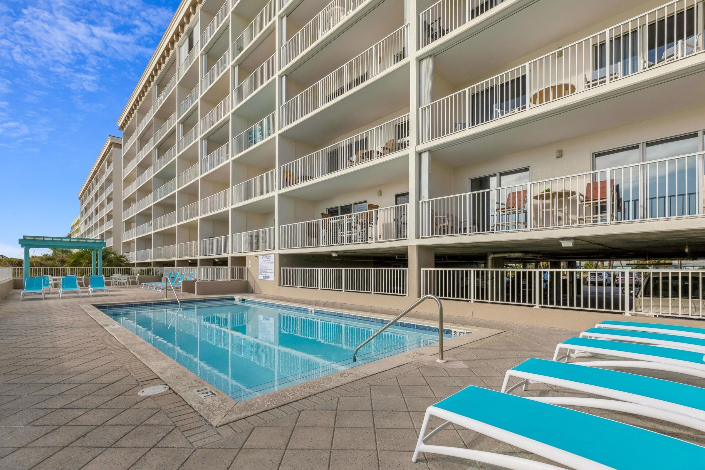 Un hôtel à plusieurs étages doté d’une piscine, d’un espace extérieur aménagé et de balcons.