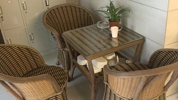 A wicker dining set with chairs and a table, accompanied by a potted plant.
