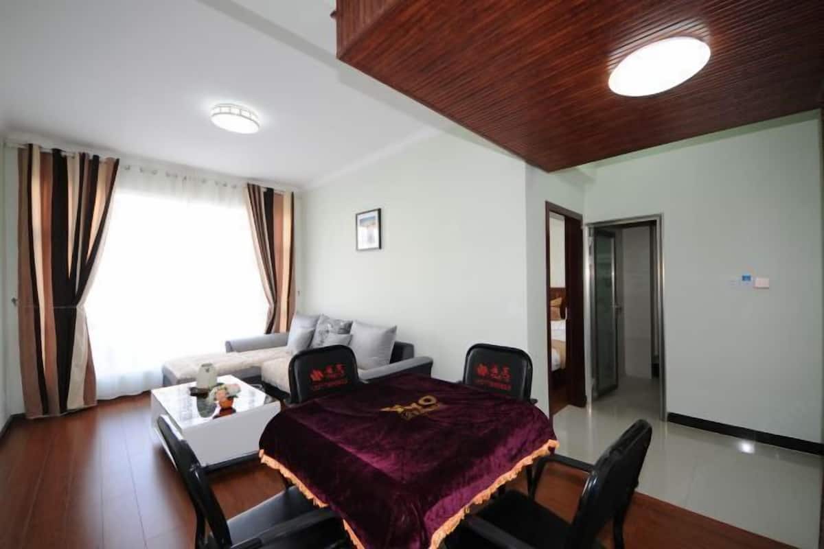 Una habitación de hotel con techo de madera, una mesa de comedor con sillas, un sofá y una cama.