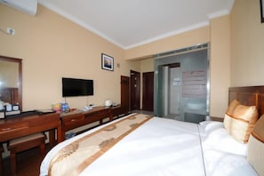A hotel room with a bed, a desk, a television, and a wardrobe. - Bandao Hotel (Binchuan)