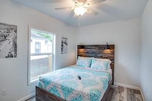 A bedroom with a bed, a ceiling fan, a window, and two wall-mounted light fixtures. - RAFTON INN VACATION RENTAL (Grafton)