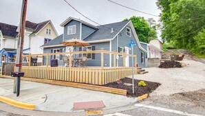 Une maison avec une terrasse, une boîte aux lettres et un panneau de signalisation.