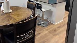 A modern kitchen with a wooden dining table, chairs, a blue door, and a microwave. - Chill & Relax 3bd (Marietta)