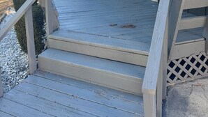 A wooden deck with outdoor seating and a blue door. - Chill & Relax 3bd (Marietta)