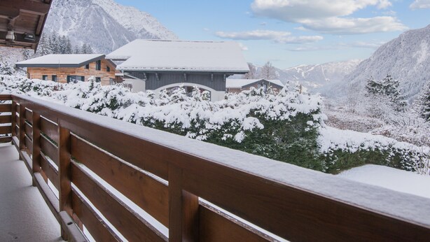 A wooden balcony with snow-covered trees and mountains in the background. - Chalet Bossons  - Welkeys (Chamonix-Mont-Blanc)