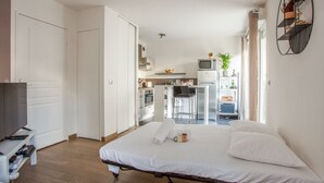 Una habitación de hotel moderna con cama, televisión, escritorio y kitchenette.