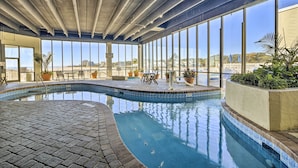 An indoor swimming pool with a clear view of the beach and buildings outside. - Ocean Views & Pool Access: Myrtle Beach Condo! (Myrtle Beach)