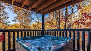 A hot tub on a wooden deck with a view of autumn trees. - Scenic Mtn View Cabin with Hot Tub (Seveirville)
