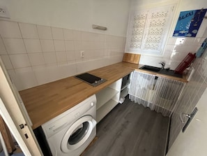 Een koelkast, een oven, kookgerei, borden en bestek
