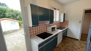 Una cocina compacta con microondas, pileta y placares.