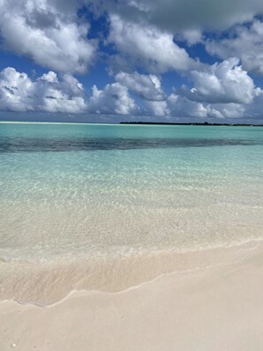 A beach with clear turquoise water and white sand.