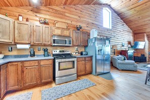 Kitchen features a large island, wooden cabinetry, and modern appliances.