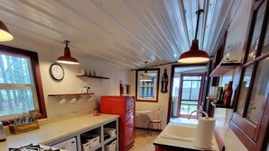 Een keuken met een gasfornuis, een koelkast en een houten tafel.