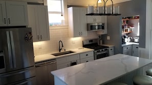 Enjoy cooking in this well-lit kitchen with a gas stove, microwave, and refrigerator.