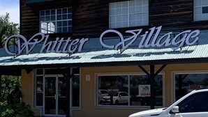A wooden building with a sign reading "Whitter Village".