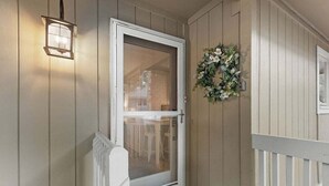 Una puerta de madera con un panel de vidrio, un buzón blanco y un adorno decorativo.