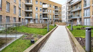 Moderni kerrostalo, jossa on keskeinen sisäpiha. Rakennuksissa on käytetty tiiltä, ja niissä on parvekkeet sekä päällystetty kävelyreitti.