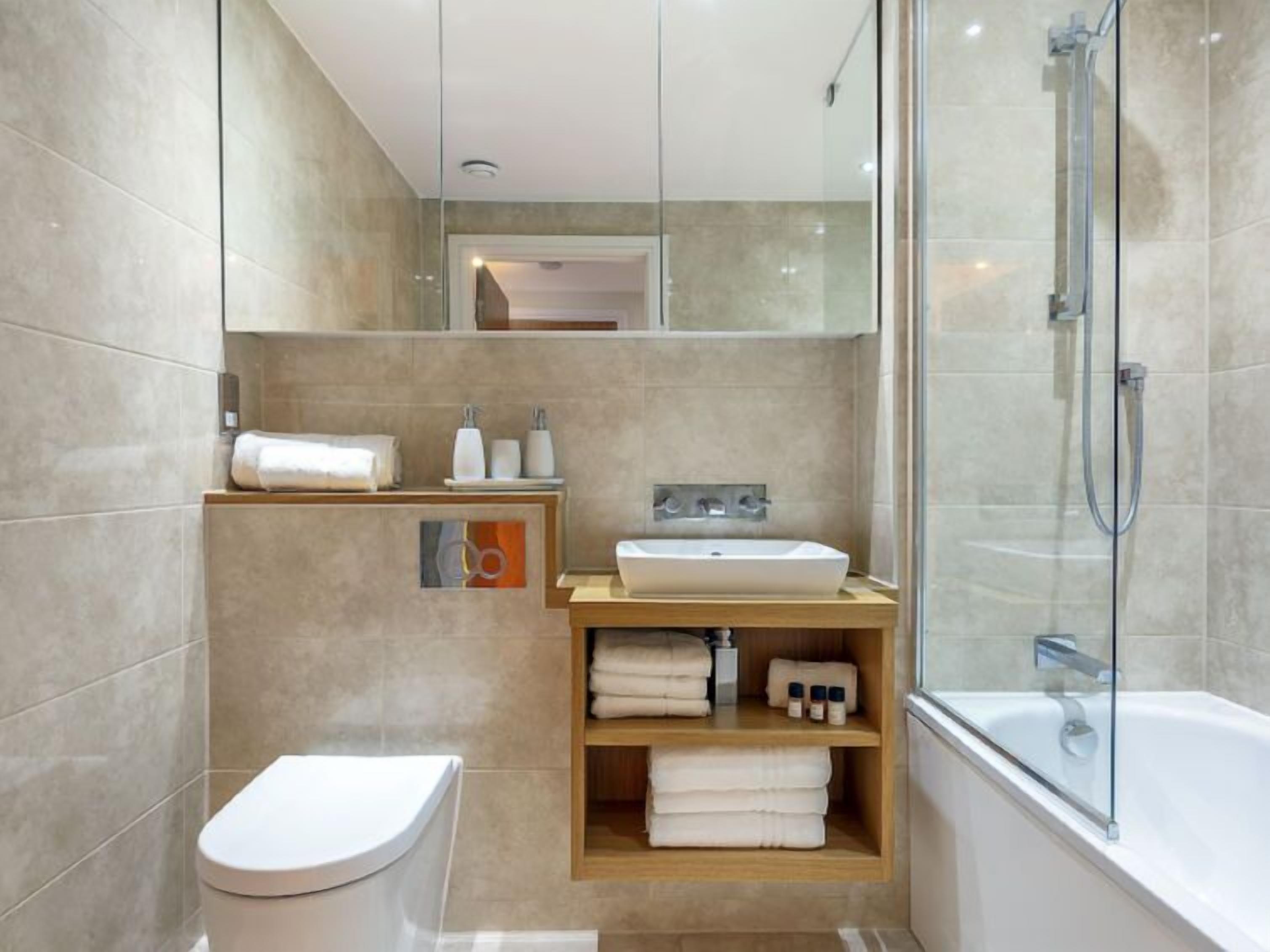 Et moderne badeværelse med toilet, håndvask og brusebad.