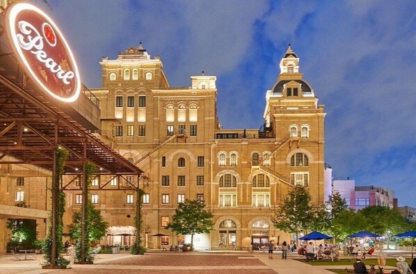 A historic building with a prominent sign for "Pearl" and a covered outdoor area with seating.