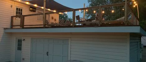 Ein zweistöckiges Gebäude mit überdachter Terrasse, Garage und Lichterketten.