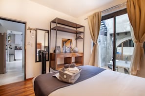 Relax in this inviting room with a large bed, desk, and seating area, offering a view of the outdoors through a large window.