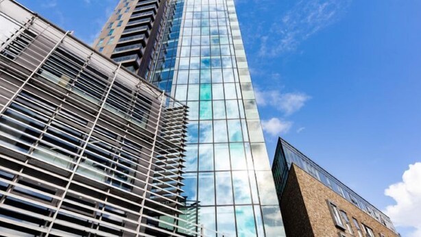 Un moderno edificio de gran altura con fachada de vidrio que refleja el cielo.