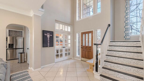 A spacious living area with a kitchen, a staircase, and a dining area. - Relax in our spacious villa, just a quick ride away to Grapevine Malls & Airport (Highland Village)