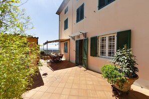 A building with a tiled patio, green shutters, and a view of the sea. - Country House / Farm House in Ciciana with 2 bedrooms sleeps 6 (Ciciana)