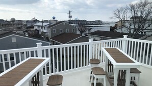 Un balcon avec des balustrades blanches et des meubles en bois.