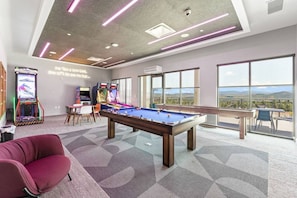 A pool table in a room with large windows and arcade games. - Canyon Haus 223 (Park City)